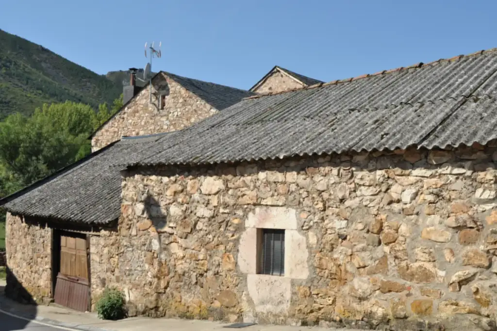Casas de piedra con cubiertas de placas onduladas de fibrocemento en un pueblo de montaña